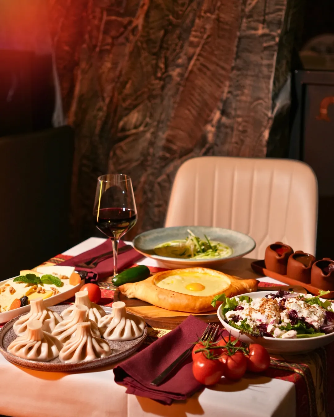 Georgian dinner spread with khinkali, adjaruli khachapuri and red wine